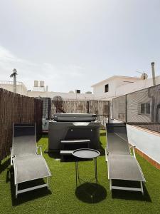 a backyard with a grill and two chairs and a table at Luxury beach penthouse with Jacuzzi in Fuengirola