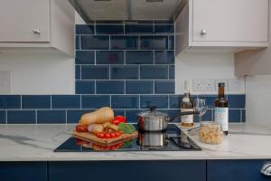 a kitchen counter with a tray of vegetables and wine bottles at Driftwood by Grandeur Property in Bournemouth +19 photos