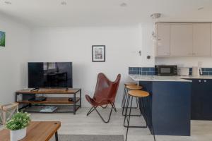 a kitchen with a counter and two chairs and a table at Driftwood by Grandeur Property in Bournemouth