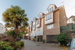 an apartment building with a palm tree next to a street at Driftwood by Grandeur Property in Bournemouth