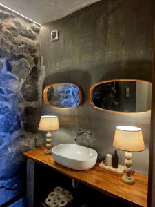 a bathroom with a sink and two lamps on a counter at Les Terrasses Suites in Calheta +33 photos