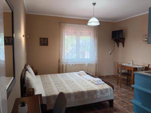a bedroom with a bed and a table and a window at Ξενώνας Αντωνία in Kato Loutraki