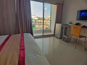 a bedroom with a bed and a desk and a window at Cox West Inn in Cox's Bazar