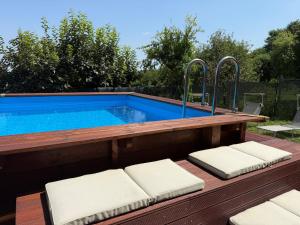 a swimming pool with two cushioned chairs in front of it at Il Borghetto di Castagnole in Castagnole Monferrato
