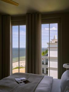 a bedroom with a bed and a view of the ocean at THE BALTIC VIEW Sellin in Ostseebad Sellin