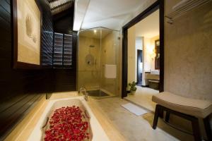 a bathroom with a bath tub filled with red roses at Golden Palm Tree Sepang in Sepang