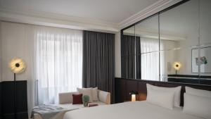 ein Schlafzimmer mit einem großen Bett und einem großen Spiegel in der Unterkunft Almanac X Alcron Prague in Prag