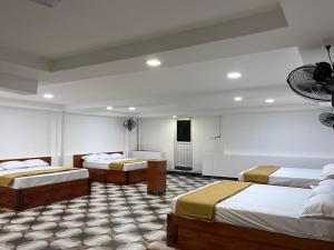 a hotel room with three beds in a room at nkm cottage in Rāmeswaram