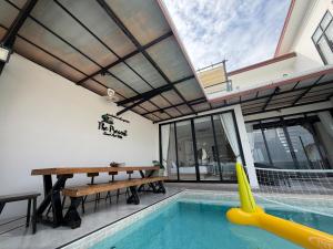 an indoor pool with a table and a pool slide at The Present Samed pool villa in Ko Samed