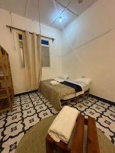 a room with two beds and a table in it at Brown & White House in Paje