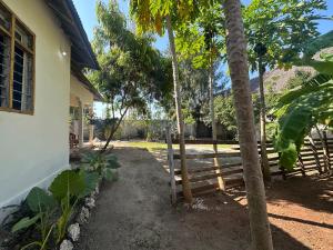 a fence in a yard next to a house at Brown & White House in Paje +49 photos