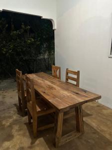 a wooden table and chairs sitting on a patio at Brown & White House in Paje