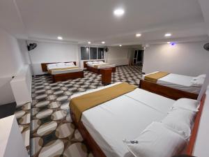 a hotel room with two beds and two tables at nkm cottage in Rāmeswaram