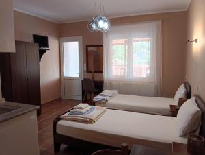 a hotel room with two beds and a window at Ξενώνας Αντωνία in Kato Loutraki