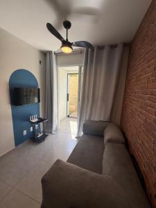 a living room with a couch and a brick wall at Apartamento Parque Trianon Exclusive in Araçatuba