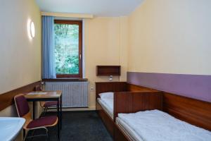 a bedroom with a bed and a table and a window at Der Sunderhof in Seevetal