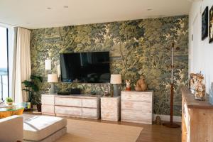 a living room with a flat screen tv on a wall at Penthouse at the Chocolate Box in Bournemouth