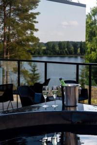 two wine glasses on a table with a view of a lake at Ikaalinen SPA & Resort in Ikaalinen