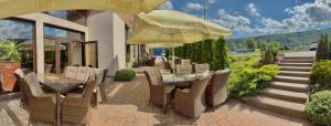 eine Terrasse mit Stühlen und einem Tisch mit Sonnenschirm in der Unterkunft ROYAL M in Sabinov