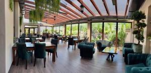 ein Restaurant mit Tischen, Stühlen und Fenstern in der Unterkunft ROYAL M in Sabinov