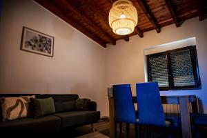 a living room with a couch and blue chairs at El Rincón del Silencio in Entrala