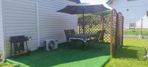 a patio with a table and chairs and an umbrella at Chatka u Goni Camp przy SUNTAGO in Grabce
