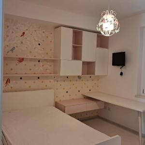 a kitchen with white cabinets and a wall with polka dots at Il Faro, Sirolo centro Vista Mare in Sirolo