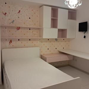 a bedroom with a white bed and a wall with butterflies at Il Faro, Sirolo centro Vista Mare in Sirolo