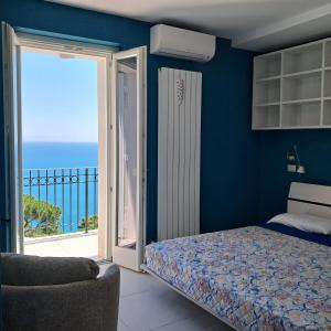 a bedroom with a bed and a balcony with the ocean at Il Faro, Sirolo centro Vista Mare in Sirolo