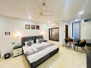 a bedroom with a bed and a table and chairs at Hotel Grand Plaza - Gate No 3 Dlf Chattarpur Farms in New Delhi
