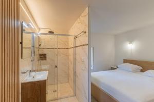 a bathroom with a shower and a sink next to a bed at "Chez Jean" à Ruoms in Ruoms +40 photos