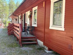 a porch of a red house with a table and chairs at Rena HOSTEL EINARA in Rena