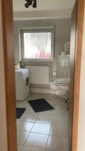 a bathroom with a sink toilet and a window at Ferienwohnung Breininger in Lemberg