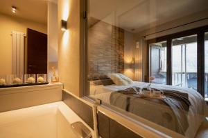 a bedroom with a bed and a tub and a mirror at Luxury Lodges by Grand Hotel Sitea in Sestriere