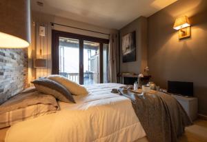 a bedroom with a large bed and a window at Luxury Lodges by Grand Hotel Sitea in Sestriere