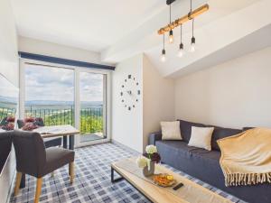 a living room with a couch and a table at Kazalnica Family&Conference Resort by Solarento in Karpacz