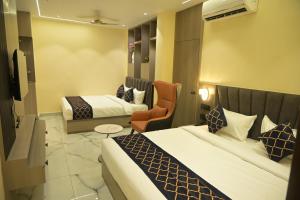 a hotel room with two beds and a chair at Hotel Bliss Kashi in Kakarmatha +41 photos