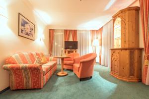 a living room with a couch and a chair at Hotel Vitalquelle Montafon in Schruns