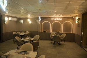 a restaurant with tables and chairs and a sign on the wall at Hotel Bliss Kashi in Kakarmatha