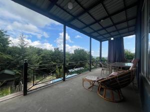 eine überdachte Veranda mit Tisch und Stühlen in der Unterkunft Ромашка in Uçgün