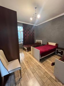 ein Schlafzimmer mit einem roten Bett und einem Stuhl in der Unterkunft Ромашка in Uçgün + 14 Fotos