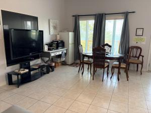 a living room with a television and a table with chairs at Q Estate Guest Suite heated indoor pool in Westport