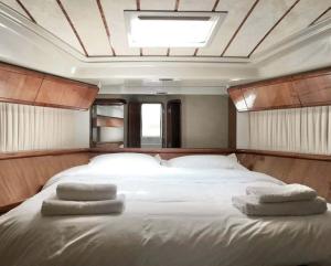 a bedroom with a large bed with three pillows on it at The Duke Superyacht - LINDIAN in Lindos