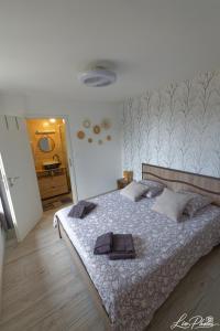 a bedroom with a bed with two towels on it at La longère in Saint-Hilaire-en-Woëvre