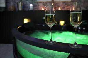 two wine glasses sitting on a table next to a hot tub at Apartmán Elarys in Nezdenice +6 photos