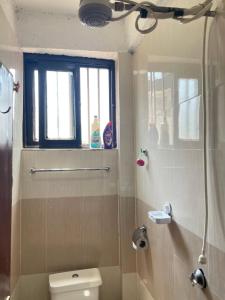a bathroom with a toilet and a window at Casa Bnb kisumu in Kisumu +26 photos