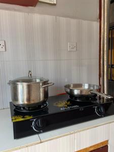 two pots on top of a stove in a kitchen at Casa Bnb kisumu in Kisumu