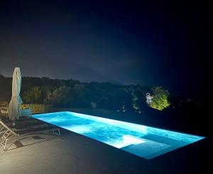 a swimming pool at night with a view at Filon Ktima Beachfront Upscale Villa in Karavádhos