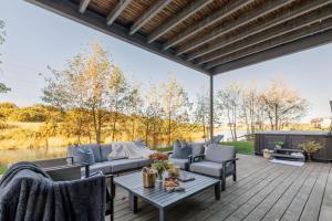a patio with a couch and chairs on a wooden deck at Silvermere in Warmwell