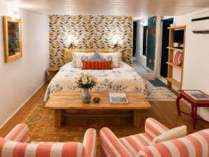 a bedroom with a bed and a table and two chairs at Kumaon Cottage, Nainital - AM Hotel Kollection in Nainital